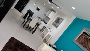 A modern living room with a white sofa, a dark brown rug, and a teal accent wall. - Capital St. (Mexico City)