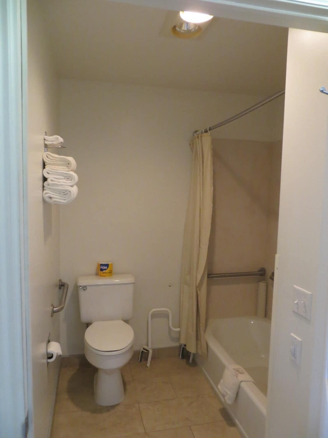 Une petite salle de bain comprenant des toilettes, une douche et un porte-serviettes.