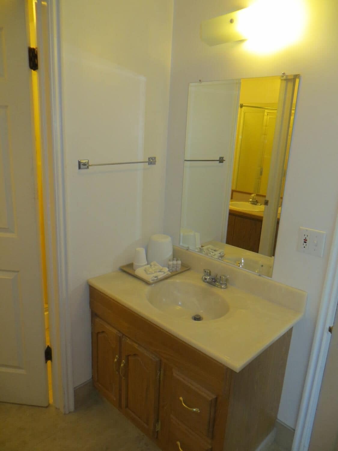 A bathroom with a sink, mirror, and wooden cabinet.