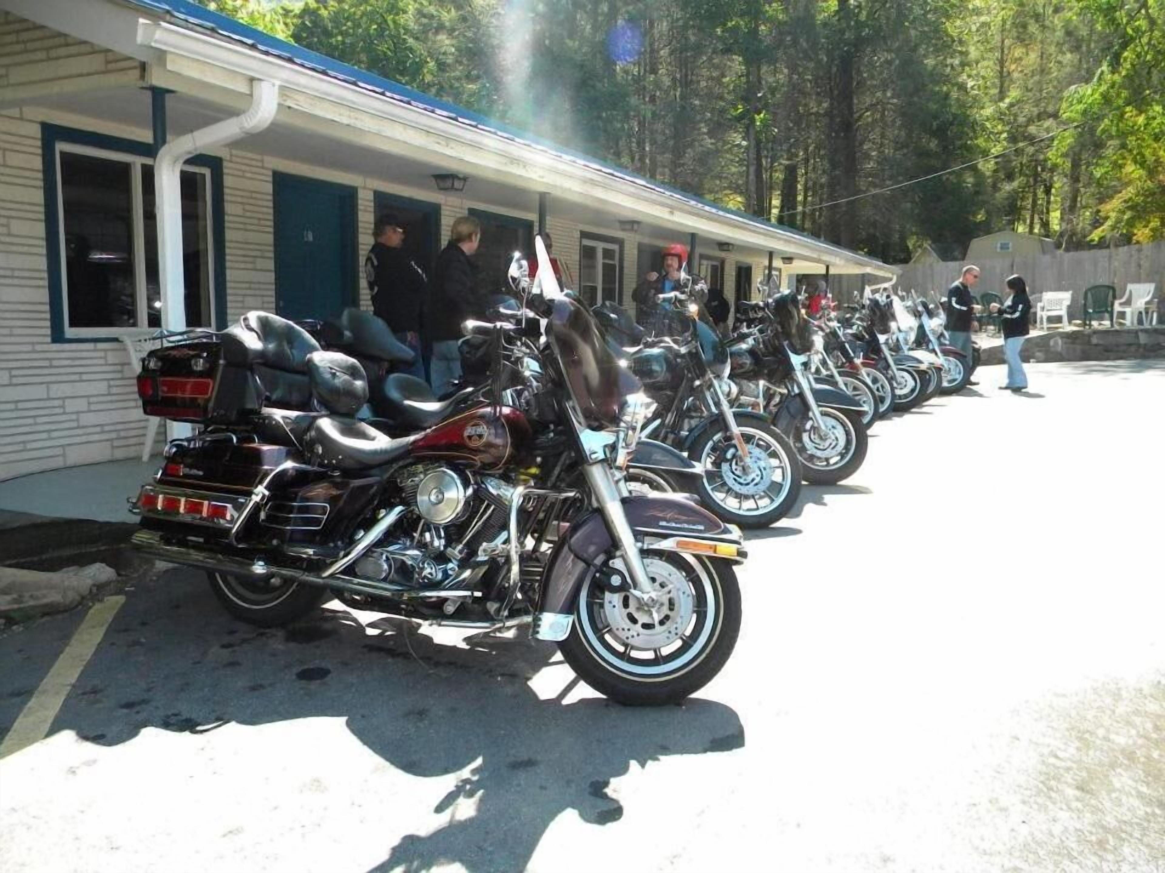 Una fila de motocicletas estacionadas frente a un edificio con porche.