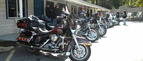 Una fila de motocicletas estacionadas frente a un edificio con porche.