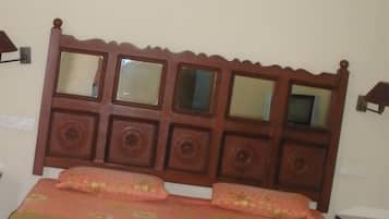 A bed with a wooden headboard featuring multiple rectangular mirrors and decorative panels.