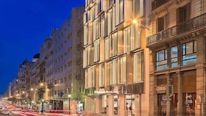 Un hotel con fachada moderna, varios pisos y un letrero llamativo.