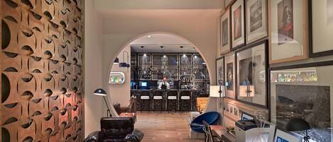 Un intérieur moderne comprenant un bar, des sièges et un bureau avec un ordinateur portable.