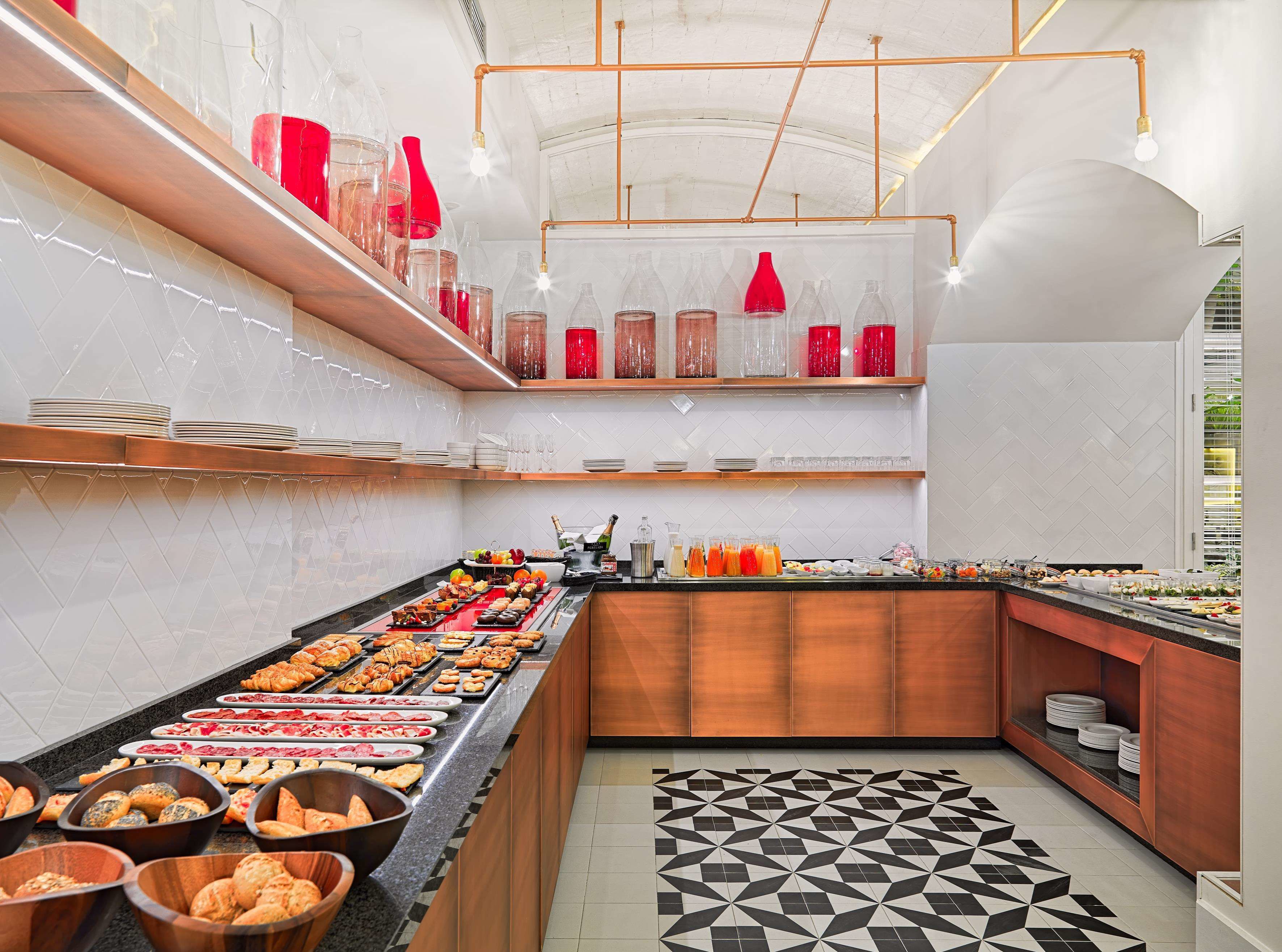 A buffet with various food items, a tiled floor, and a modern kitchen with copper fixtures.