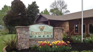 A sign for Forest Edge Winery with a stone border and a flower bed in front. - Bourbon Manor B&B (Bardstown)