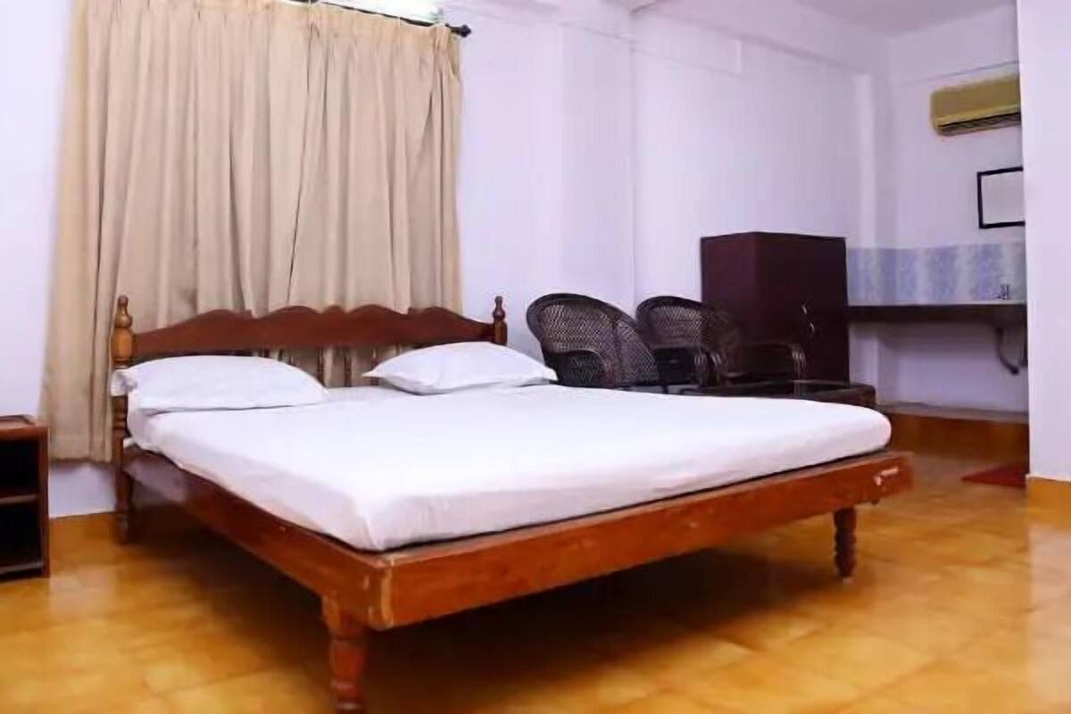 A single bed with a wooden headboard in a room with a wooden floor.