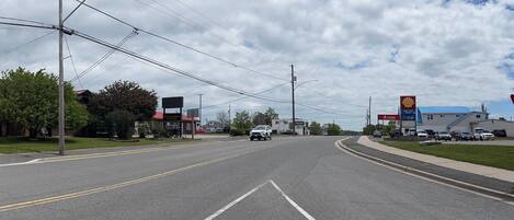 A road with a motel sign, a Shell gas station, and a clear sky.