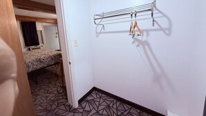 Une petite pièce, de taille modeste, équipée d’un lit superposé et d’un étendoir métallique fixé au mur.