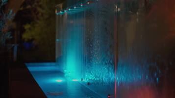 A water feature with a reflective surface and illuminated edges.