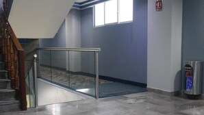 Un espace intérieur moderne doté d’une rambarde en verre, d’un escalier et d’un système d’alarme incendie.