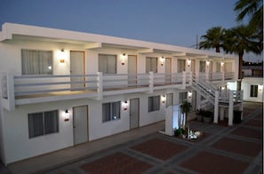 A multi-story hotel with a white exterior, balconies, and a central staircase. - Eco Bay Hotel y Restaurant (Bahía Kino)