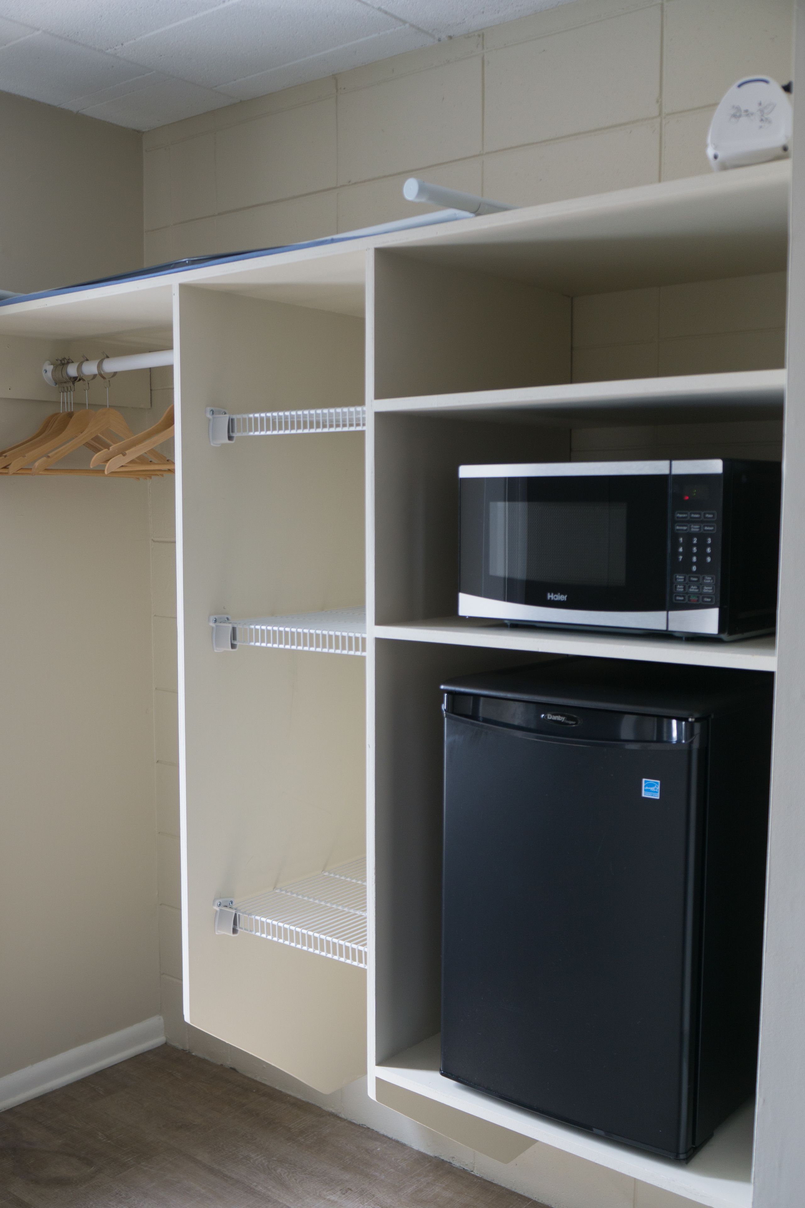 A compact kitchen with a microwave and a black refrigerator.