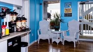 A kitchen with coffee makers, a trash bin, and a sign for the Charlrov Motel. - Charlroy Motel (Seaside Park)