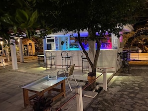 Relax with a drink at this outdoor seating area, featuring a glass-top table and comfortable bar stools.