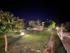 Relax in a serene outdoor space with a beautifully manicured lawn, stone pathway, and comfortable seating areas.