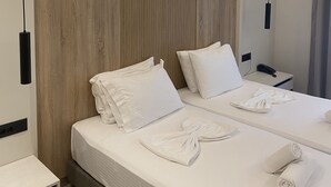 Ein Hotelzimmer mit einem großen Bett, zwei Nachttischen und einem Spiegel.