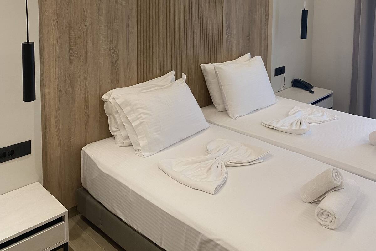 Ein Hotelzimmer mit einem großen Bett, zwei Nachttischen und einem Spiegel.