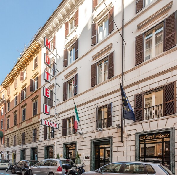 Un hôtel reconnaissable à son enseigne bien visible, à ses nombreuses fenêtres et à ses drapeaux.