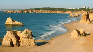 A coastal beach with large rock formations and a clear view of the sea. - Interpass VAU Hotel & Apartaments (Portimão)