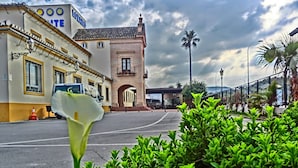 A hotel with a traditional facade, a central archway, and a parking area. - Hotel Lozano (Antequera)