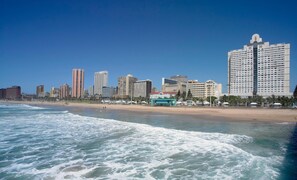 A coastal cityscape with high-rise buildings, a beach, and ocean waves. - Garden Court Marine Parade (Durban)