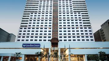 A high-rise hotel with a prominent central entrance, multiple floors, and a well-lit facade.