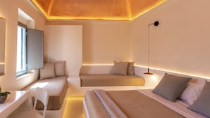 Un dormitorio moderno y minimalista con una cama grande, un escritorio y una zona de estar.