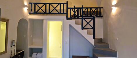 Ein Schlafzimmer mit Treppe, Schreibtisch und Stuhl.