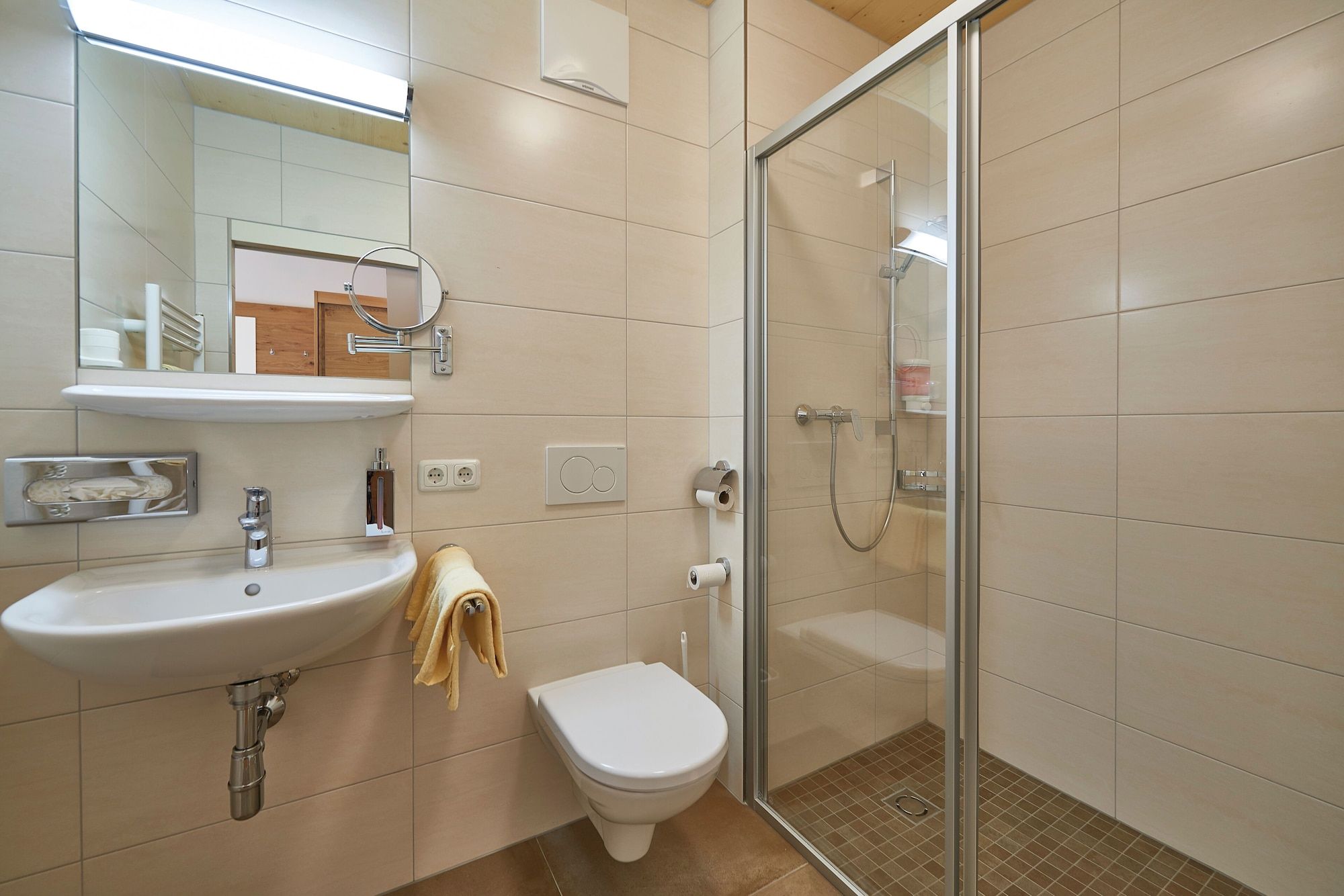 Ein modernes Badezimmer mit Waschbecken, Toilette und einer Duschkabine.