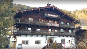 Ein traditionelles Holzhaus mit einem Schild, auf dem "Gasthof" und "Limberghof" steht.