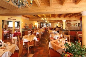 Enjoy a classic European dining experience in this cozy restaurant with a traditional wooden ceiling and elegant chandeliers.