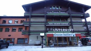 Un edificio con un cartel que dice 'Unterwirt' y 'Sauna - Solarium - Baño de Vapor'.
