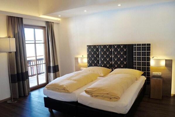 Cozy retreat with a double bed, two bedside tables, and a large window with curtains.