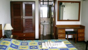 A bedroom with a bed, a desk, a mirror, a sink, and a wardrobe. - Mobor Beach Resort (GOA)