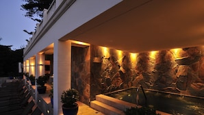 Un área de spa con hidromasaje, pared de piedra y zona de estar.