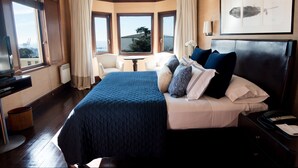 Habitación de hotel con una cama grande, un escritorio y vistas a la ciudad.