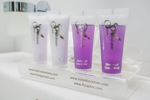 Three tubes of shower gel labeled 'San Antonio' on a display stand with hotel website URLs. - Jona Split Rooms (Podstrana)
