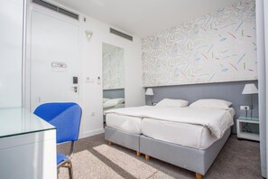 A bedroom with a double bed, a chair, a desk, and a wall with a leaf pattern. - Jona Split Rooms (Podstrana)