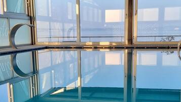 Ein großes Hallenbad mit klaren Glaswänden und einer Metallkonstruktion für das Dach.