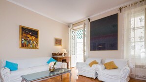 A living room with two white sofas, a glass coffee table, and a painting on the wall. - Klarina Apartments (Split)
