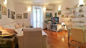 A modern living room with a sofa, TV, and a glass dining table. - Klarina Apartments (Split)