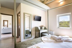 A hotel room with a bed, a desk, a television, and a window with a view. - Three Stars (Corfu)