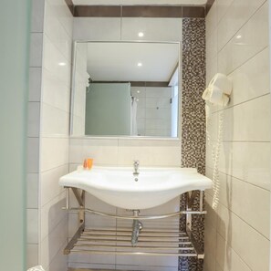 A bathroom with a white sink, a mirror, and a shower. - Three Stars (Corfu)
