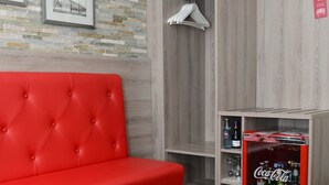 A modern room with a red sofa, a wooden wardrobe, and a Coca-Cola refrigerator. - Granus (Aachen)