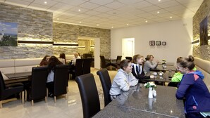 Un comedor moderno con paredes de piedra, un sofá y una mesa con sillas.