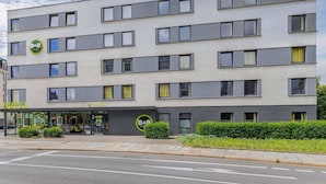 Un hôtel moderne, avec un hall d’accueil, de nombreux étages et un ciel dégagé.