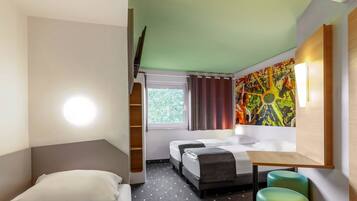A hotel room with a bed, two bedside tables, a desk, a chair, and a window with curtains.