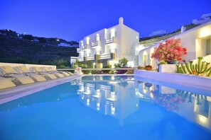 Un hôtel moderne doté d’une piscine, d’une façade blanche et de balcons offrant une vue sur une colline.