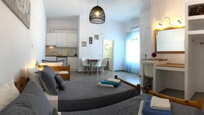 A compact bedroom with two beds, a kitchenette, a dining area, and a walk-in closet. - Villa Gambas (Santorini)